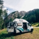 Cute vintage camper van or camping RV parked in wild camping spot in mountain forest