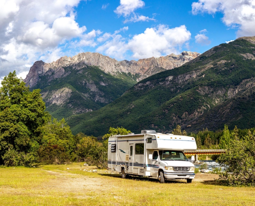 Side view of an RV by a scenic mountain
